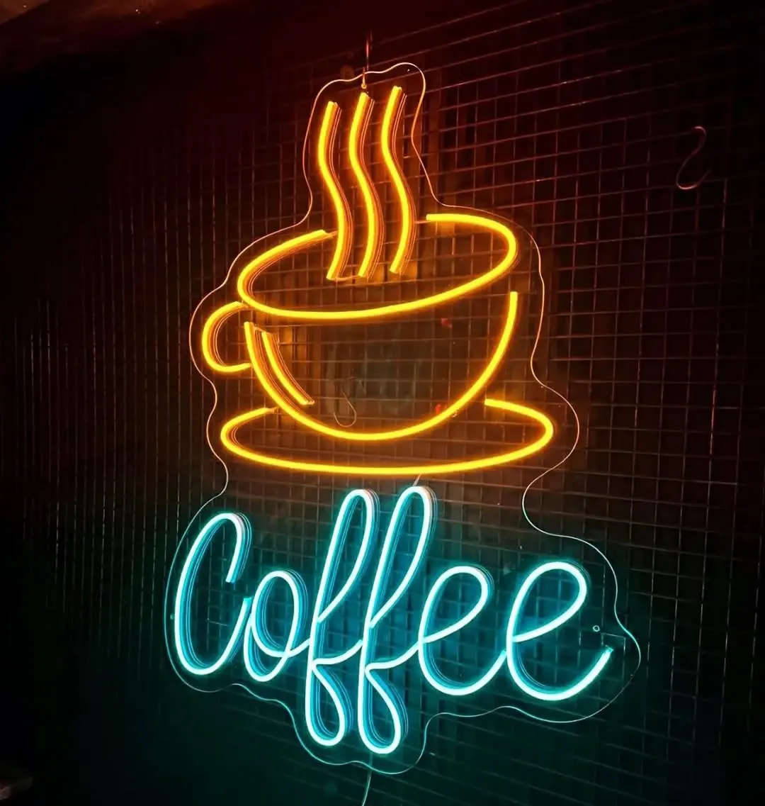 Tuğla duvarda amber dumanlı kahve fincanı ve turkuaz 'Coffee' el yazısı neon