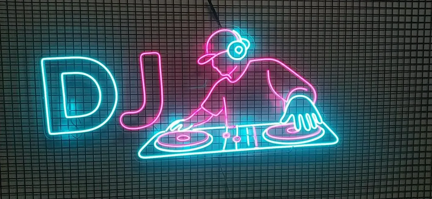 Turkuaz ve pembe 'DJ' yazısı ve pikap başında DJ figürü neonu
