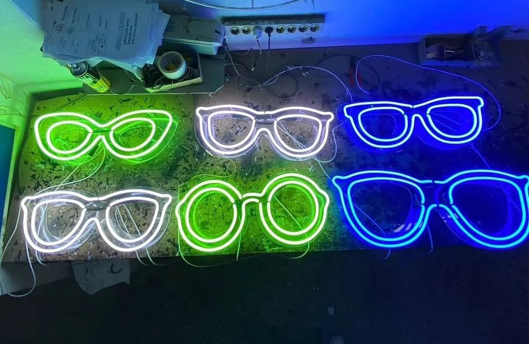 Optik mağazası için yeşil, beyaz ve mavi gözlük biçimli neonlar