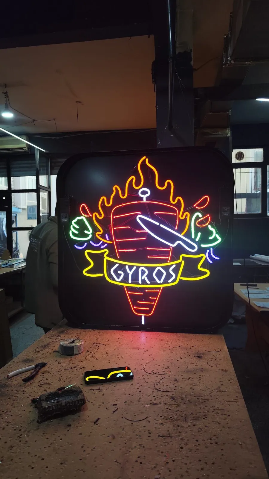 Multicolour glass neon of a flaming doner with 'GYROS' lettering on a black box