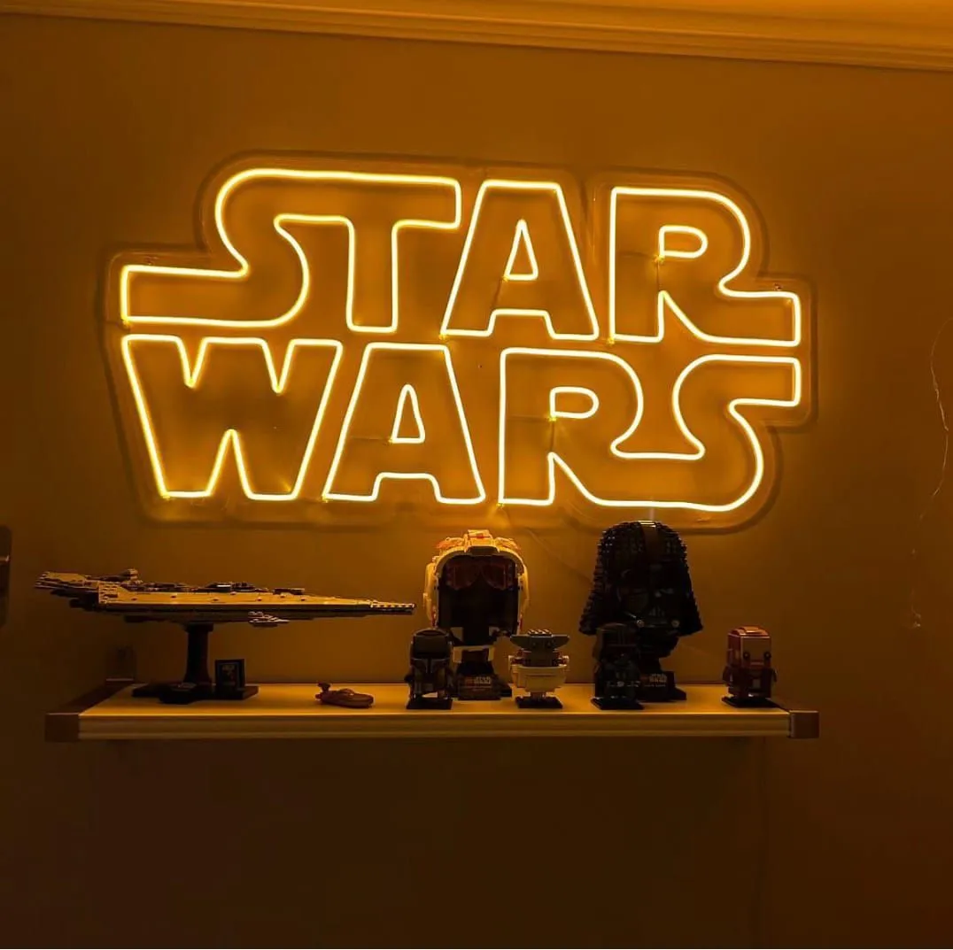 Koleksiyon rafının üstünde amber 'Star Wars' logo neonu