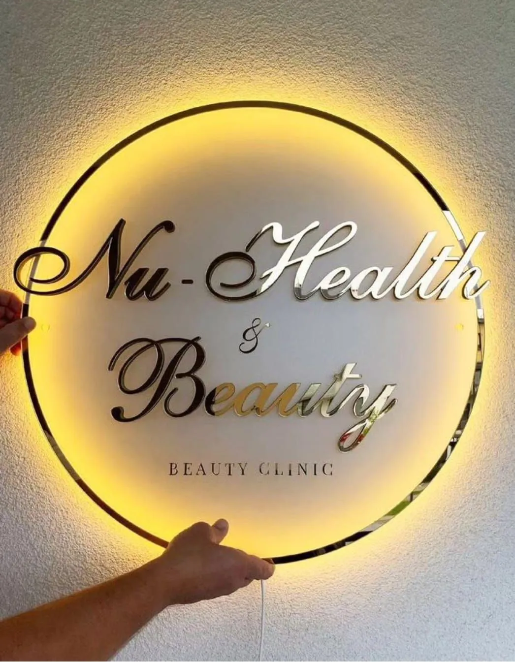 Round beauty clinic sign with gold mirror acrylic letters and an indirect back light